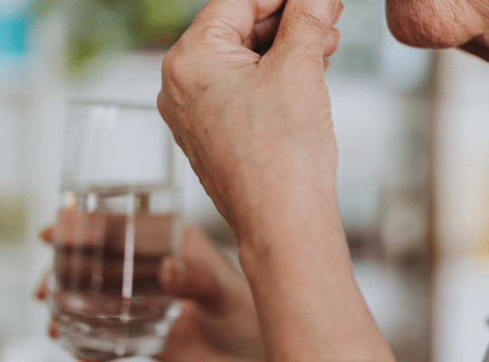 Persona tomando medicamento en casa siguiendo tratamiento